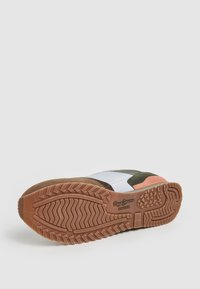 Sneaker con suola in gomma, caratterizzato da un mix di pannelli in tessuto bianco, verde e arancione, e una suola beige testurizzata con motivi di scolpitura.