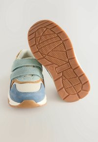 Sneakers with a blue suede toe, tan accents, white mesh upper, and two light blue velcro straps. The rubber sole features a zigzag pattern.