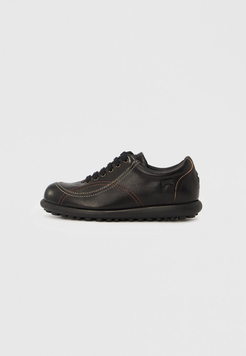 Μαύρο δερμάτινο αθλητικό παπούτσι με κορδόνια, με αντίθετη λευκή και καφέ ραφή και στρογγυλεμένη, υφή σόλα.