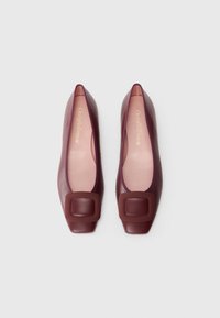 Ballet flats in burgundy leather with a square toe and large square buckle accent. Soft pink interior lining. Elegant minimal design.
