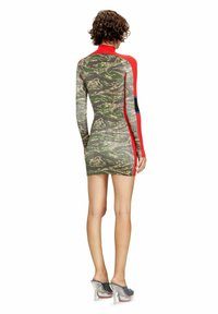 Mini abito con motivo mimetico, maniche lunghe rosse e design aderente. Presenta strisce verticali a contrasto in blu e nero. Tacchi trasparenti.