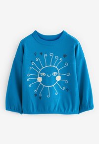 Sweatshirt blu a coste con un design a sole ricamato in bianco e blu navy e raggi a spirale, faccia rotonda e polsini arricciati.