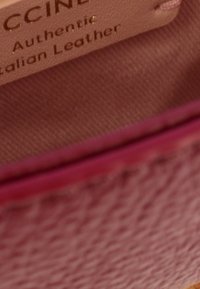 Intérieur de sac en cuir italien rose avec une texture lisse, présentant une étiquette portant l'inscription "Cuir Italien Authentique" en lettres dorées.