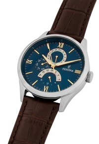 Brūns ādas siksniņas pulkstenis ar pulētu sudraba korpusu, tumši zilu ciparnīcu, zelta toņa romiešu cipariem, datuma rādītājiem un daudzfunkcionālu dizainu.