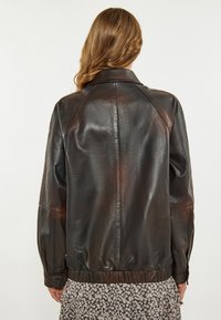 Braune Lederjacke mit glatter Textur, Raglanärmeln und geripptem Saum. Verfügt über einen klassischen Kragen und knöpfbare Manschetten.