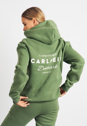 Grøn hættetrøje med kengurulomme og hvidt trykt tekst på ryggen, lavet af blødt stof med en afslappet pasform.