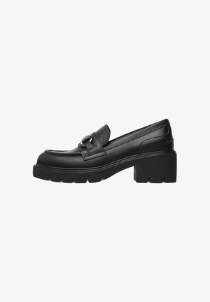 Schwarze Lederloafer mit einer dicken Plattformsohle, ausgestattet mit einer dekorativen Metallbuckle und glatter Oberfläche. Geschlossene Zehenpartie.