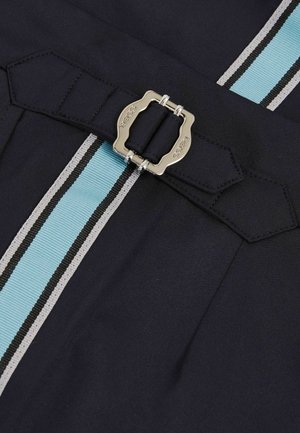 Marineblåt stof med en tekstureret overflade, prydet med en sølvspænde og to vertikale striber i lyseblå og sort.