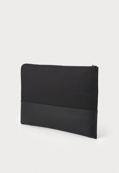 Sort clutch taske lavet af stof med en tekstureret læderbund. Har en lynlåslukning i toppen; simpel, rektangulær form.
