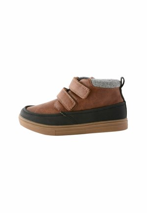 Brązowe skórzane buty typu high-top z szarym kołnierzem z polarowego materiału, czarnymi akcentami i podwójnymi rzepami. Gumowa podeszwa zapewnia przyczepność i trwałość.