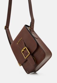 Borsa a tracolla in pelle marrone con forma rettangolare, dettaglio della fibbia dorata e cuciture tono su tono. Tracolla regolabile, design pulito.