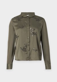 Camisa de seda verde oliva con mangas largas, cuello y bordado floral de lentejuelas negras. Cierre frontal con botones y un diseño ajustado.