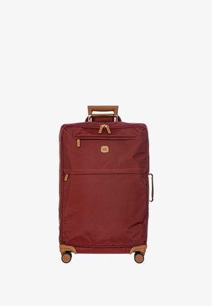 Valise en nylon rouge avec des accents en cuir marron ; équipée d'une poignée télescopique, de compartiments zippés et de quatre roues pour une mobilité aisée.