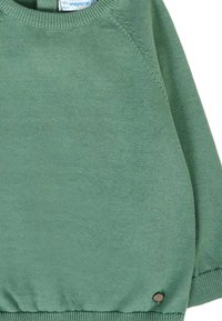 Maglione verde a maglia con maniche raglan, collo rotondo e un piccolo dettaglio in bottone decorativo vicino all'orlo. Texture morbida, vestibilità casual.
