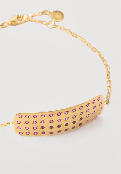 Χρυσό βραχιόλι με καμπυλωτή ορθογώνια πλάκα διακοσμημένη με πέντε σειρές μικρών ροζ πολύτιμων λίθων, συνδεδεμένο με ένα λεπτό χρυσό αλυσίδα.