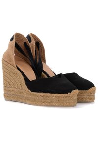 Espadrillas con zeppa in tela nera, suole in juta e dettagli intrecciati in tonalità marrone, dotate di cinturini incrociati alla caviglia e design a punta chiusa.