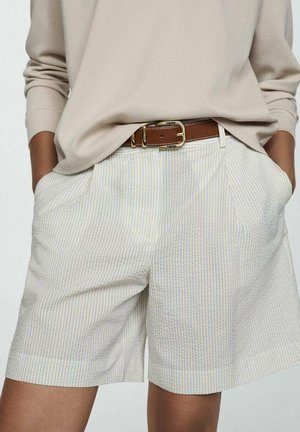 White shorts with subtle blue and yellow stripes, featuring side pockets and a textured fabric, paired with a brown belt and beige top.