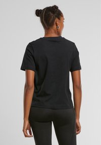 Zwarte katoenen t-shirt met een ronde hals en korte mouwen; minimalistisch ontwerp met een relaxed fit en geen zichtbare patronen of logo's.