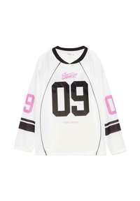 Weißes Longsleeve-Trikot mit Netzstruktur, verfügt über schwarze Akzente, eine auffällige schwarze "09" auf der Vorderseite, pinken "Stay United"-Text und kontrastierende Ärmelverzierungen.