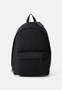 Sac à dos en tissu noir avec un motif circulaire en relief, sommet arrondi, poche zippée à l'avant et une poignée supérieure pour un transport facile.