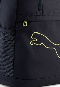 Marine rugzak met een gaas zijvak, een geel logo van een springende kat en een ritsvak aan de bovenkant voor veilige opslag.