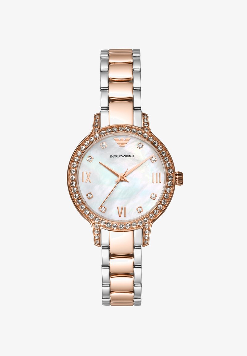 Orologio in metallo dorato e argentato con quadrante rotondo in madreperla bianca, dettagli in oro rosa e una lunetta incastonata di cristalli. Indicatori in numeri romani.