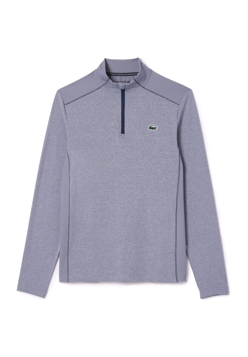 Helles graues Langarm-Pullover mit Reißverschlusskragen, aus strukturiertem Stoff, mit marineblauen Akzenten und einem kleinen grünen Logo auf der Brust.