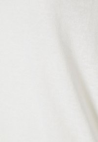 Primo piano di un tessuto bianco semplice con leggere pieghe e un pattern di trama visibile.