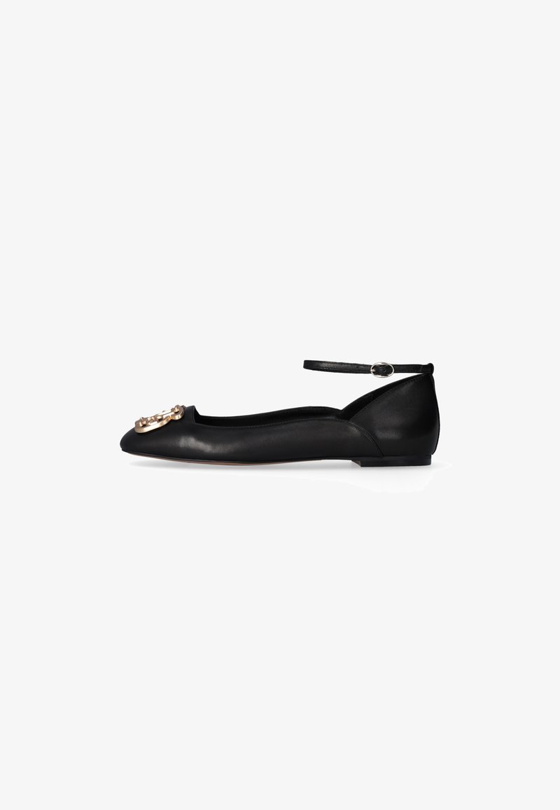 Scarpa piatta in pelle nera con punta affusolata, cinturino alla caviglia con fibbia e decorazione ornamentale dorata sulla punta.