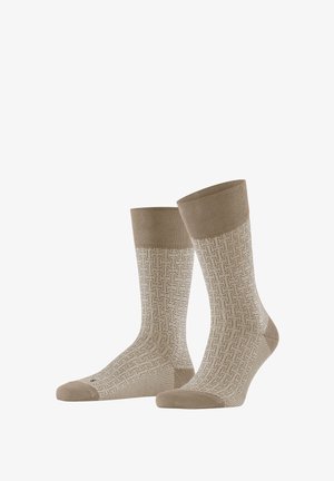Paar beige Knöchelsocken mit einem geometrischen weißen Webmuster, durchgehend beige Zehen, Fersen und Bündchen.