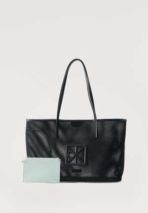 Bolso tote negro perforado con un parche cuadrado de logo y asas largas, junto a una pequeña bolsa con cremallera de color azul claro.