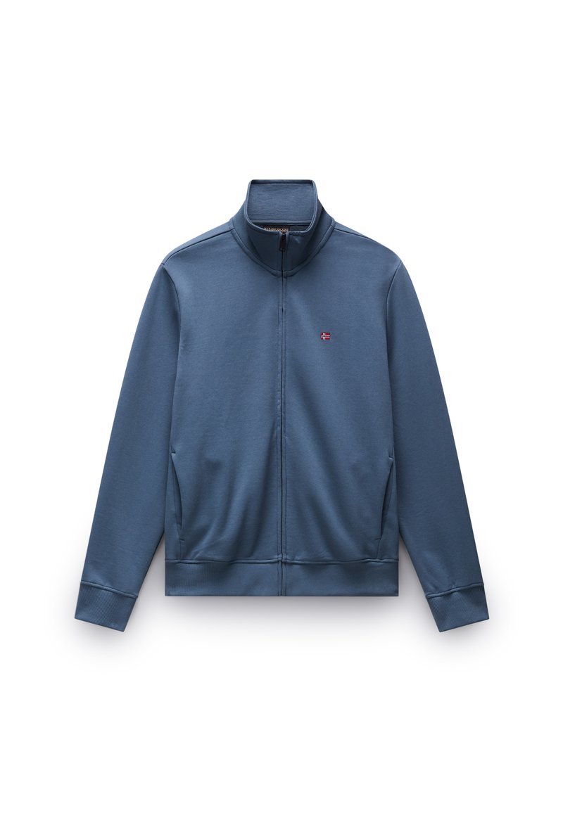 Chaqueta azul con cremallera y cuello alto, hecha de un tejido suave. Cuenta con bolsillos laterales y un pequeño logotipo en el pecho.