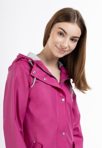 Jachetă impermeabilă fucsia, cu căptușeală gri la glugă, nasturi metalici argintii și detalii cu șnur. Prezintă o croială lejeră și un design de lungime medie.