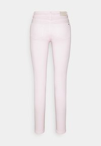 Jeans ajustados de mezclilla en rosa claro, con una cintura alta, bolsillos traseros y una pequeña etiqueta de logo en la parte trasera de la cintura, con textura suave.