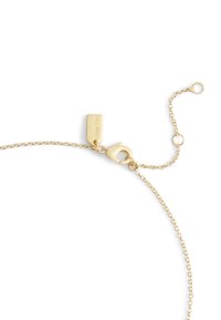 Collana a catena tono oro con chiusura a gancio e lunghezza regolabile. Presenta un'etichetta rettangolare con marchio inciso.