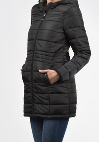 Schwarze Steppjacke mit einem Reißverschluss, Kapuze und Seitentaschen. Verfügt über horizontale Nähte und eine glatte, glänzende Textur.