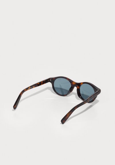 Tortoiseshell sunglasses with round lenses, blue-tinted glasses, and slender arms. Textured arms with a glossy finish and curved edges.