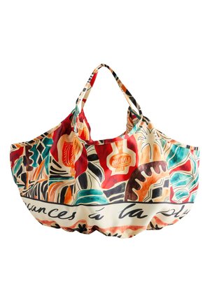 Sac cabas coloré avec des motifs botaniques et géométriques abstraits en rouge, orange, bleu sarcelle, noir et crème avec un texte en cursive sur la bordure.