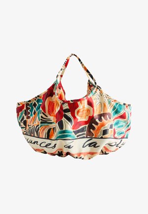 Sac cabas coloré avec des motifs botaniques et géométriques abstraits en rouge, orange, bleu sarcelle, noir et crème avec un texte en cursive sur la bordure.