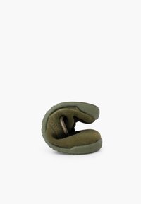 Green, flexible shoe with a textured fabric upper and rubber sole, folded over to display its soft material and durable design.