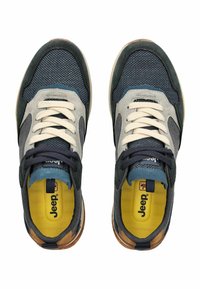 Sportovní boty s vrškem z síťoviny a semiše v šedé a námořnické modři, krémovými tkaničkami, žlutou vložkou a gumovou podrážkou s hnědými akcenty.