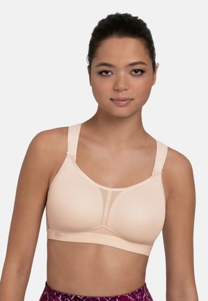 Bra in soft nude color, featuring smooth fabric, mesh detailing at the front, and adjustable straps. Designed for comfort and support.