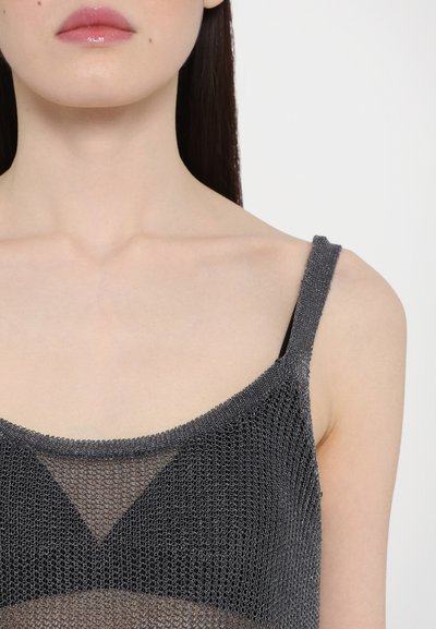Grijze mesh top met fijne brei structuur, met dunne bandjes en een driehoekig ontwerp. De onderlaag is zwart, wat contrast creëert.