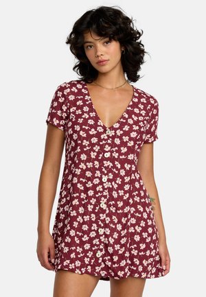 Diep bordeauxrode bloemenjurk met korte mouwen, een diepe V-hals en een knoopsluiting aan de voorkant. Voorzien van kleine witte en roze bloemen en een lichte, gestructureerde stof.