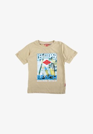 T-shirt beige à manches courtes avec le texte "LEE COOPER" et un graphisme représentant des planches de surf, des palmiers et l'océan sous le mot "BEACH".