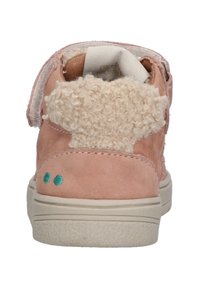 Zapatilla de ante rosa con un acento peludo de color crema en la parte trasera, que presenta una suela de goma blanca y costuras decorativas en turquesa.