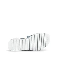 Blue sandal with a textured upper and a white rubber sole featuring deep grooves for traction. Brand logo present on the sole.