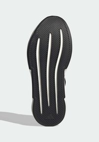 Czarna gumowa podeszwa buta z teksturowanym bieżnikiem, posiadająca trzy wyraźne rowki i subtelny biały akcent, zaprojektowana dla zapewnienia przyczepności i wsparcia.