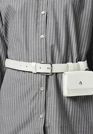 Ceinture en cuir blanc avec une boucle rectangulaire en argent, portée sur une chemise grise à rayures avec des boutons de couleur claire. Comprend une petite pochette blanche.