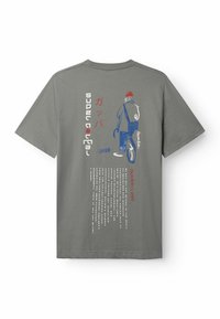 Šedé bavlnené tričko s grafickým dizajnom postavy na bicykli. Text na chrbte v rôznych písmach, niektoré v japončine.